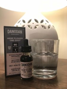 Danodan CBD on a nightstand next to a lamp and glass of water.