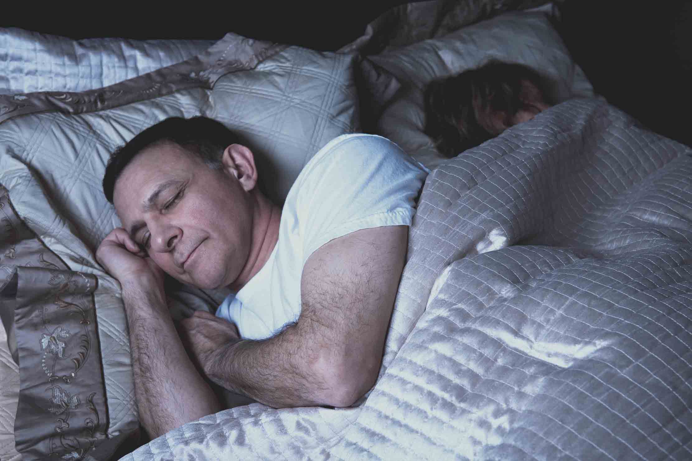 Man and woman sleeping soundly in bed.