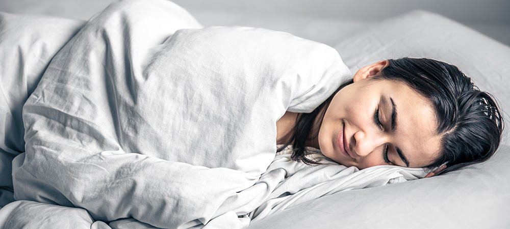 Woman sleeping well after using full spectrum CBD oil tinctures for sleep & insomnia. Buy organic CBD online.